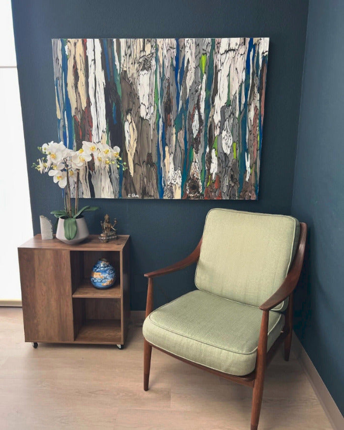 A large abstract painting of trees in a contemporary office