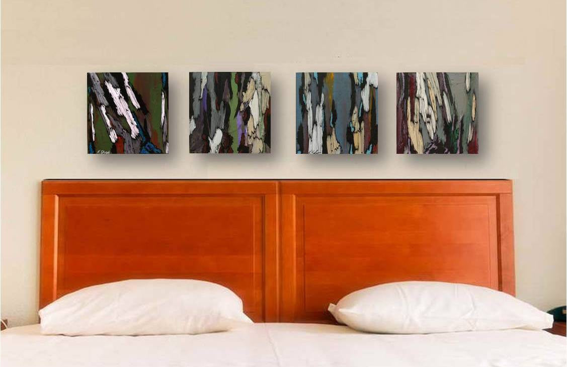 Four abstract original paintings hung horizontally above a contemporary bed in a bedroom or hotel room. Paintings are small and colors are muted.