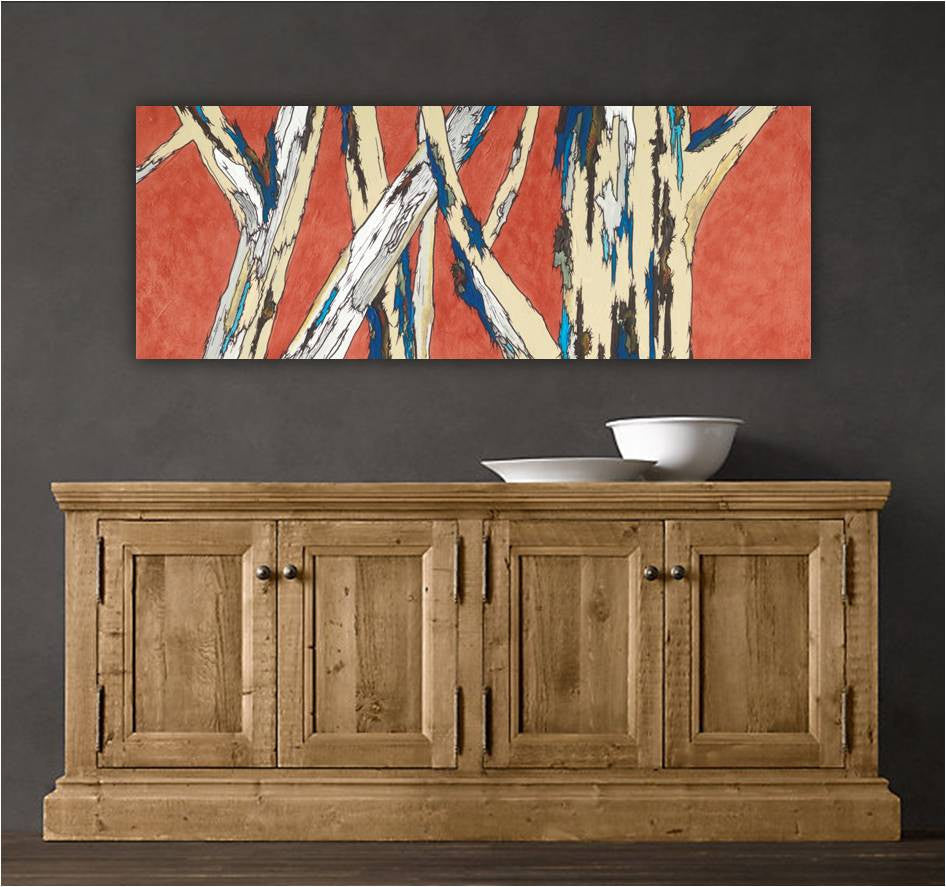An orange, blue, and white canvas wall art print featuring tree trunks, above a modern rustic cabinet.