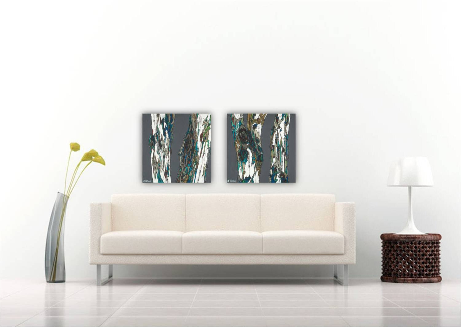 Original set of 2 large tree paintings in gray, with white, blue, green accents. Bold and dramatic. Above a couch in a white living room.