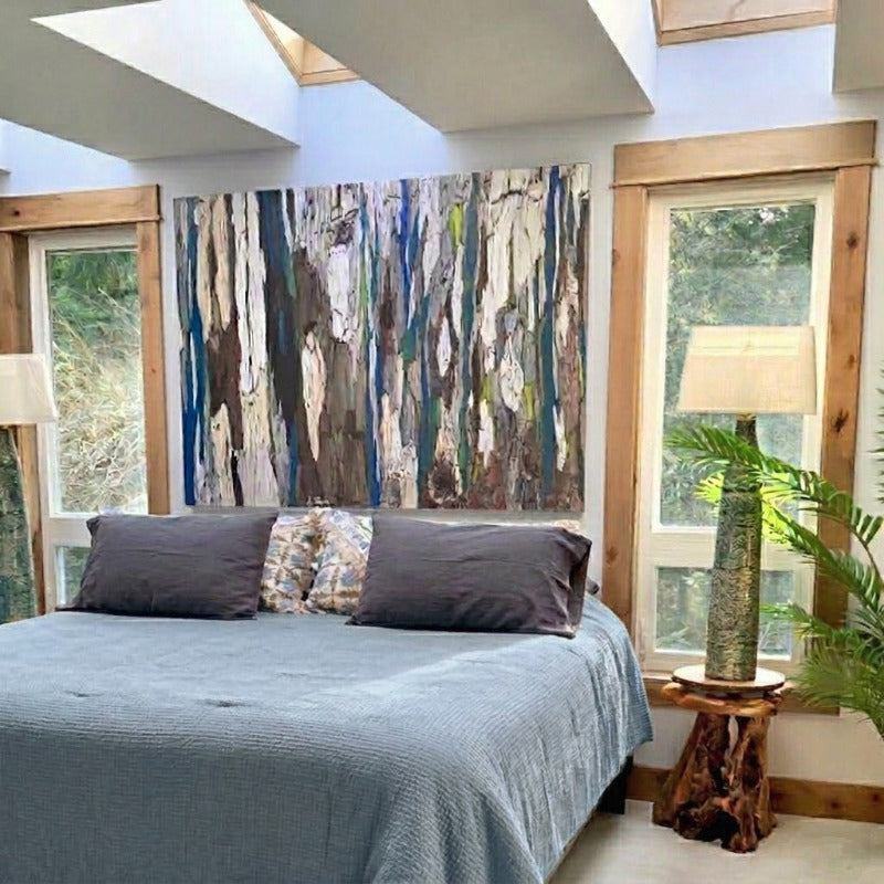 Modern bedroom with a bed, abstract wall art, and natural light