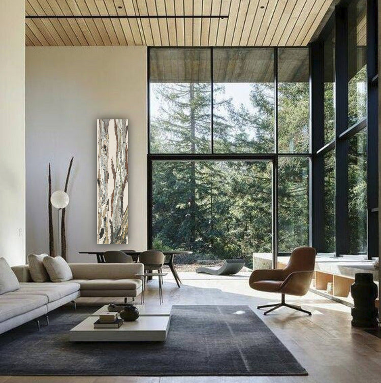 Modern living room with vertical artwork of trees in a landscape