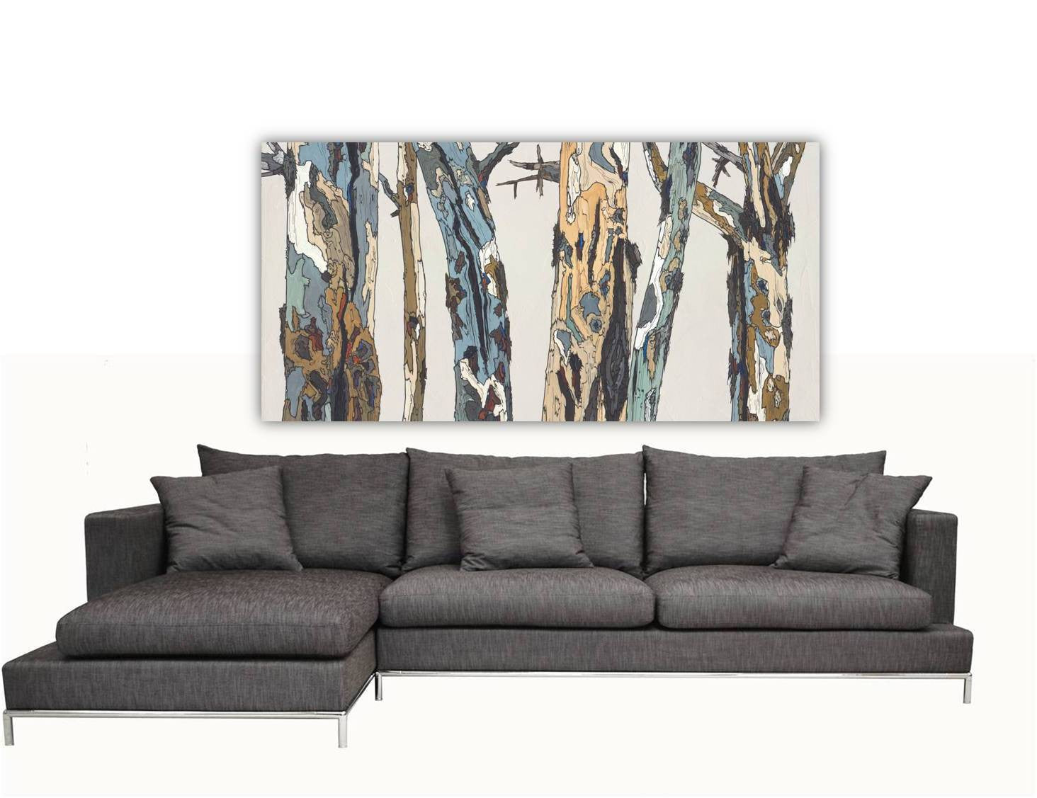 Extra Wide Horizontal Canvas Wall Art of trees & landscape sweeping in a modern space above a huge sofa.