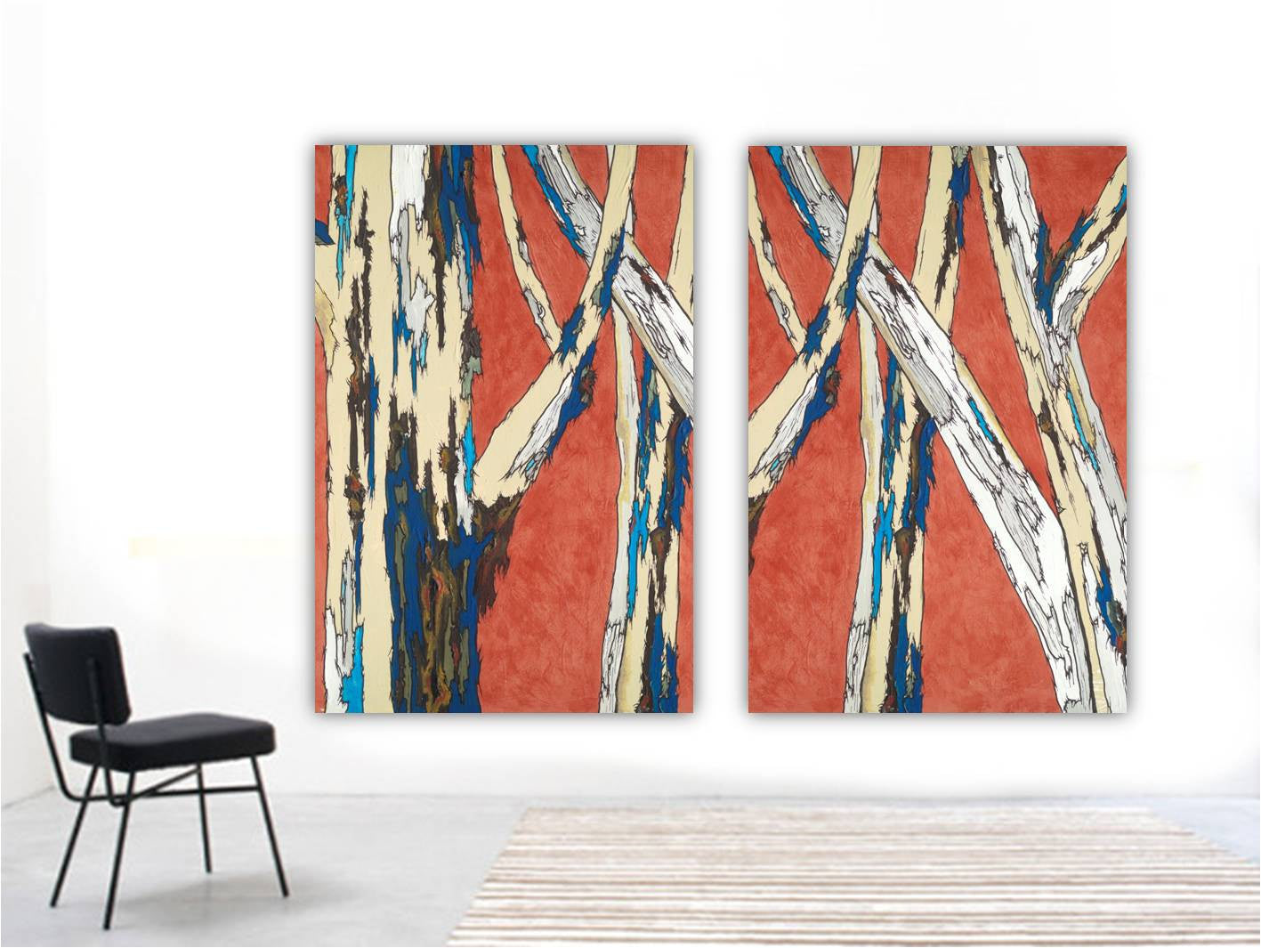 Two oversized deep orange canvas art panels with blue and white tree landscape on a huge blank wall in a modern space.