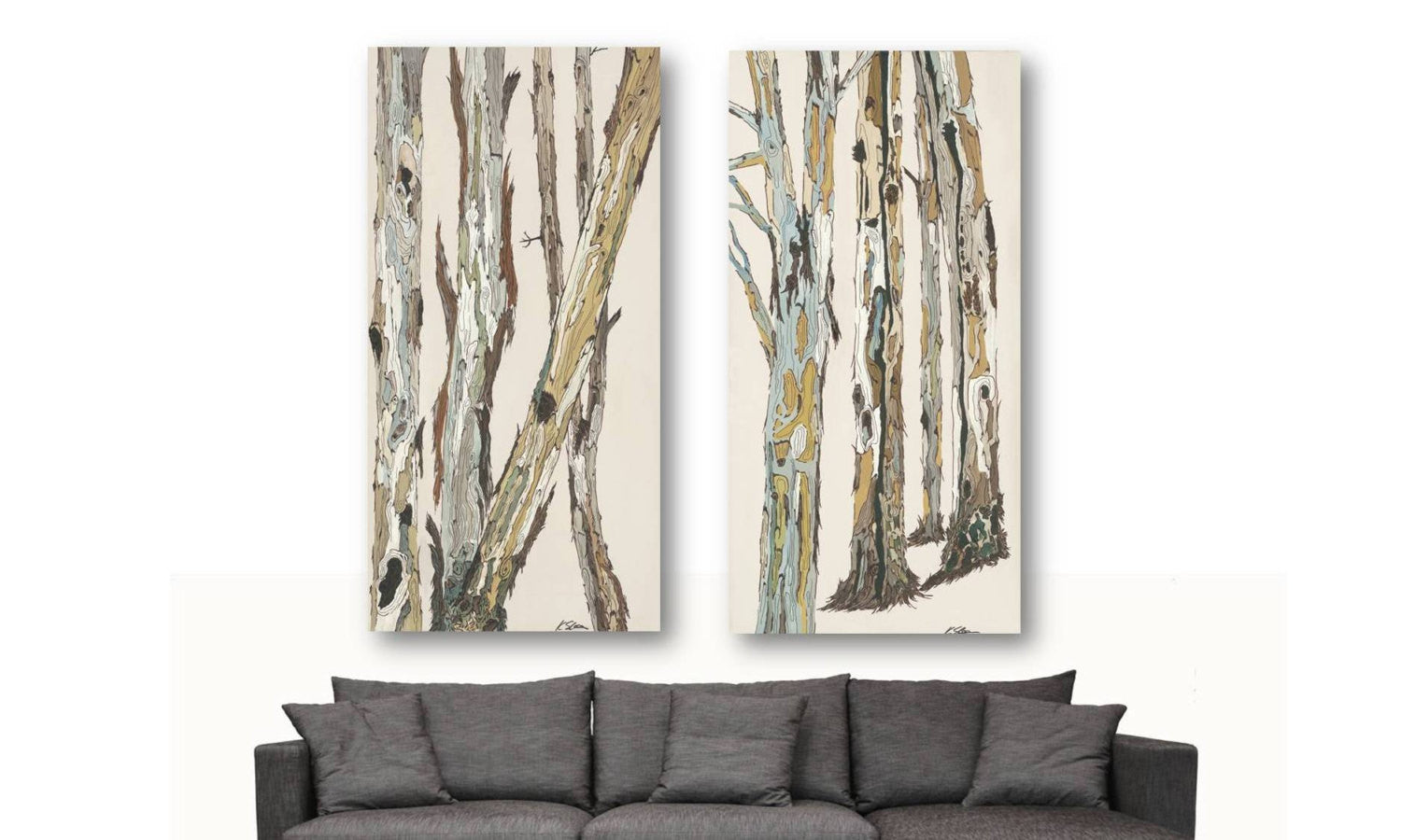 Oversized vertical set of 2 tree art panels on large empty wall above a contemporary decor couch.