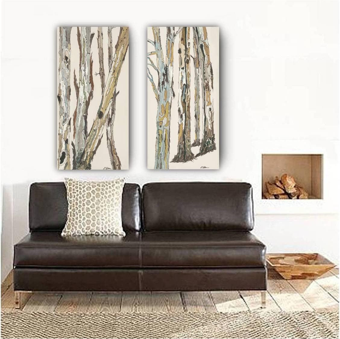 Two canvas art prints of trees in light & airy colors, above a leather seat in a rustic modern space